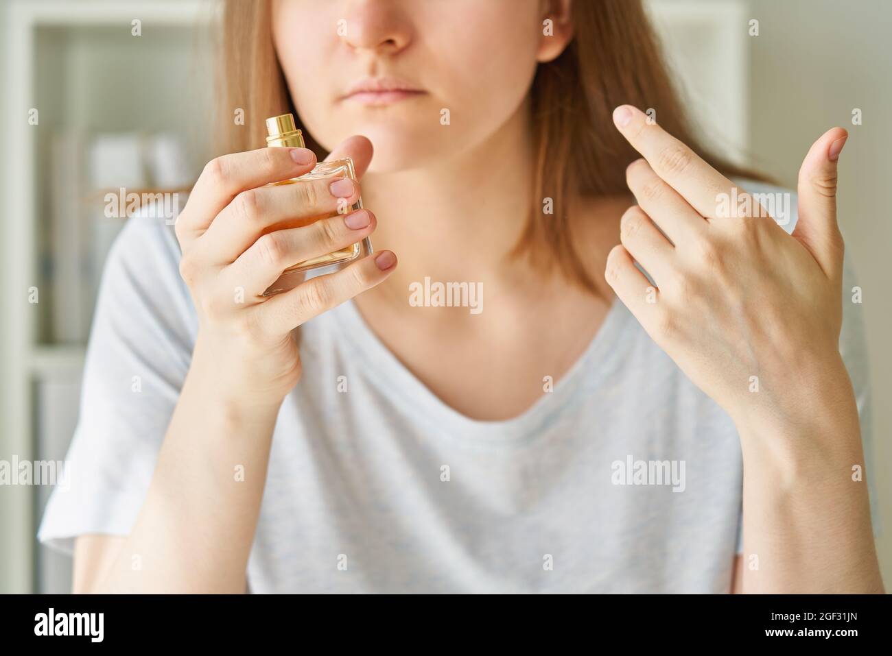 Kranke weibliche schnüffende Parfümflasche, hat eines der möglichen Symptome einer Corona-Virus-Infektion Stockfoto