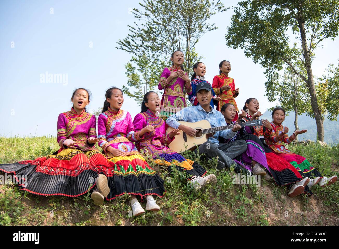 Chengdu, Chinas Provinz Sichuan. August 2021. Mädchen und ihre Lehrerin singen im Freien in der Stadt Dacao im Bezirk Puge, Autonome Präfektur Liangshan Yi, südwestlich der chinesischen Provinz Sichuan, am 6. August 2021. Der Mädchenchor an der zentralen Grundschule von Dacao im Bezirk Puge erregte große Aufmerksamkeit, nachdem die Videos ihrer Performances auf kurzen Videoportalen geteilt wurden. Der Chor wurde in diesem Sommer zu einem Musikfestival in Peking, der Hauptstadt Chinas, eingeladen. Quelle: Xu Bingjie/Xinhua/Alamy Live News Stockfoto