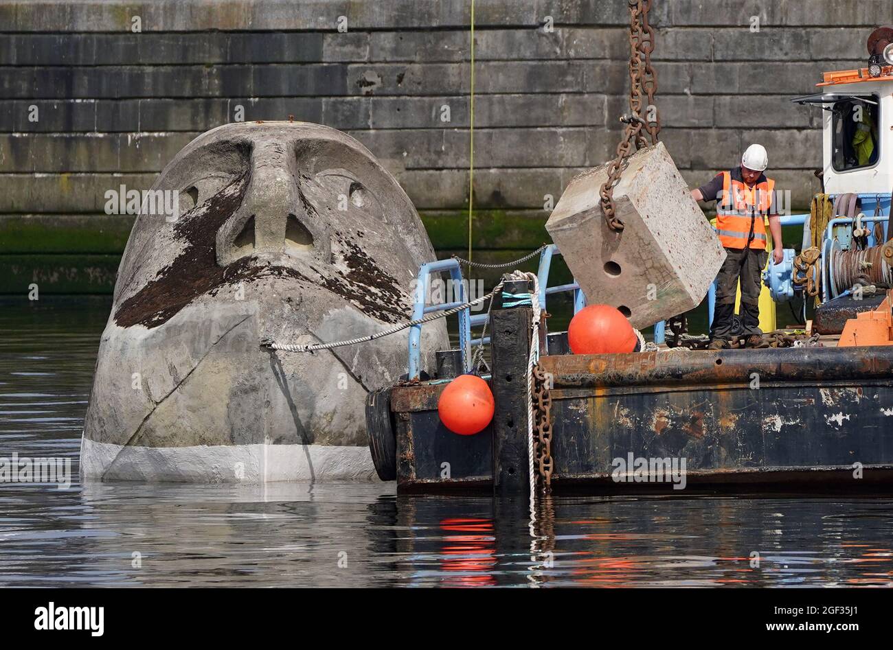 Die 27 Tonnen schwere Skulptur Floating Head aus Beton und Stahl des Künstlers Richard Groom wird etwa 33 Jahre nach ihrer Entstehung für das Glasgow Garden Festival am Fluss Clyde in der Nähe des Glasgow Science Center aufgestellt. Bilddatum: Montag, 23. August 2021. Stockfoto