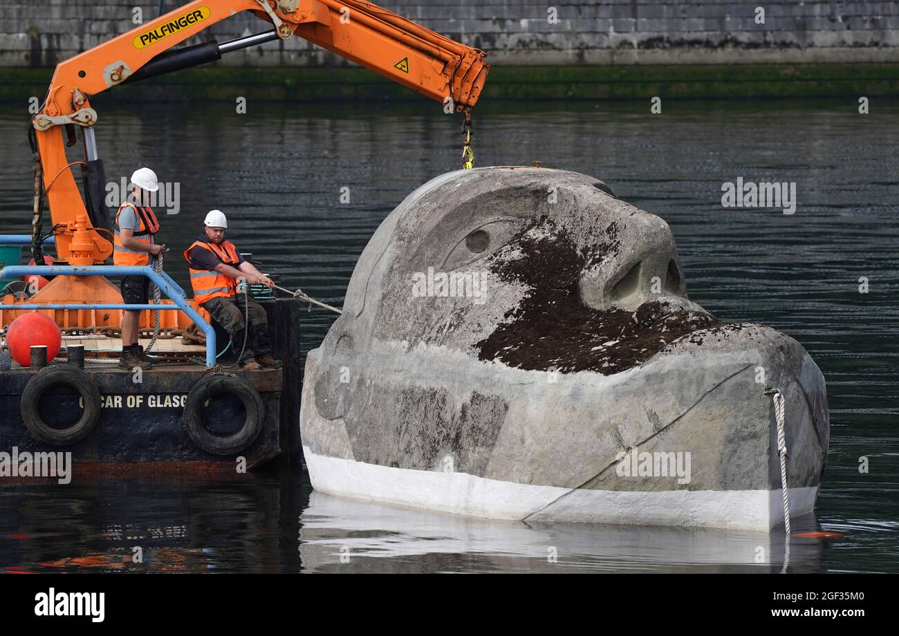 Die 27 Tonnen schwere Skulptur Floating Head aus Beton und Stahl des Künstlers Richard Groom wird etwa 33 Jahre nach ihrer Entstehung für das Glasgow Garden Festival am Fluss Clyde in der Nähe des Glasgow Science Center aufgestellt. Bilddatum: Montag, 23. August 2021. Stockfoto