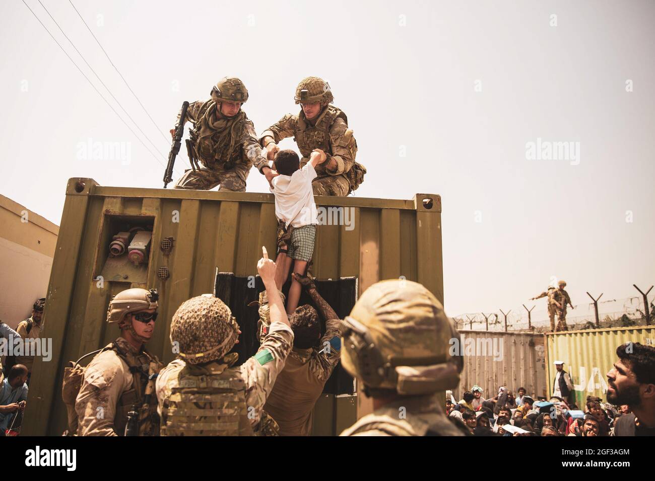 Britische Koalitionstruppen, türkische Koalitionstruppen und US-Marineinfanteristen unterstützen ein Kind bei einer Evakuierung am Hamid Karzai International Airport, Kabul, Afghanistan, 20. August. US-Dienstmitglieder unterstützen das Außenministerium bei einer nicht-kämpferischen Evakuierungsoperation (NEO) in Afghanistan. (USA Marine Corps Foto von Staff Sgt. Victor Mancilla via Sipa USA) Bitte beachten Sie: Die von der Agentur berechneten Gebühren sind ausschließlich für die Dienstleistungen der Agentur bestimmt und dienen nicht dazu, dem Benutzer das Eigentum an dem Copyright oder der Lizenz an dem Material zu vermitteln. Das Reisebüro erhebt keinen Anspruch auf Eigentumsrechte, einschließlich BU Stockfoto