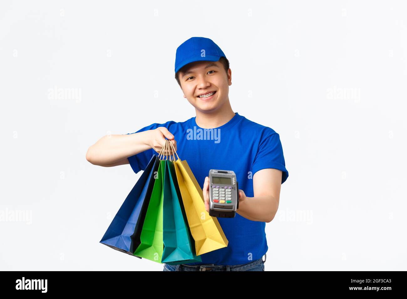 Kontaktloses Bezahlen, Shopping und Home Delivery Konzept. Lächelnd angenehm asiatischen Kurier in blauer Uniform bringen Client-Auftrag an die Haustür, Übergabe Stockfoto