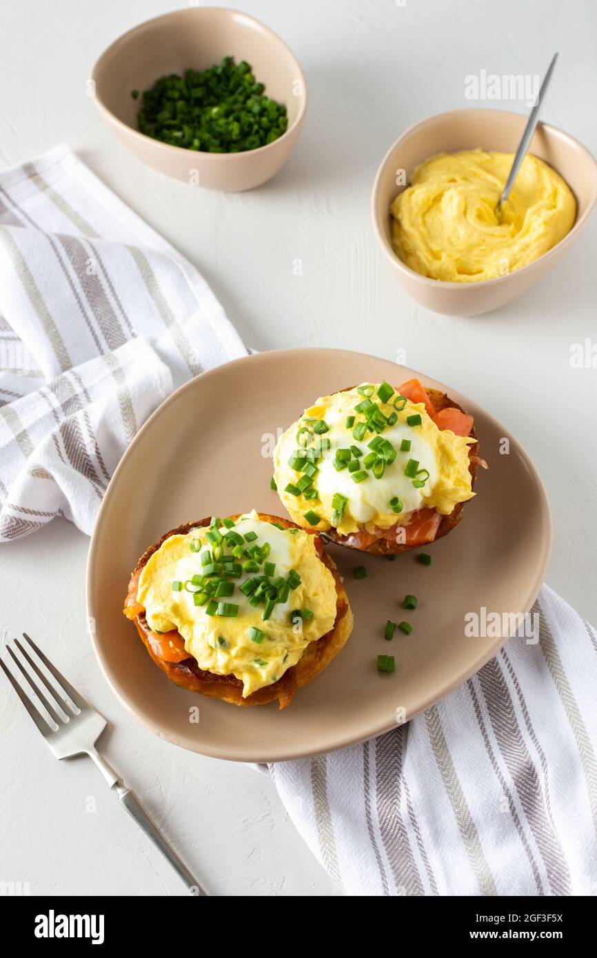 Leckeres herzhaftes Frühstück, Eier Atlantic in einem Teller auf weißem Hintergrund, Runde gebratene Brötchen mit Lachs und Eier Benedikt, Sauce Hollandaise Stockfoto