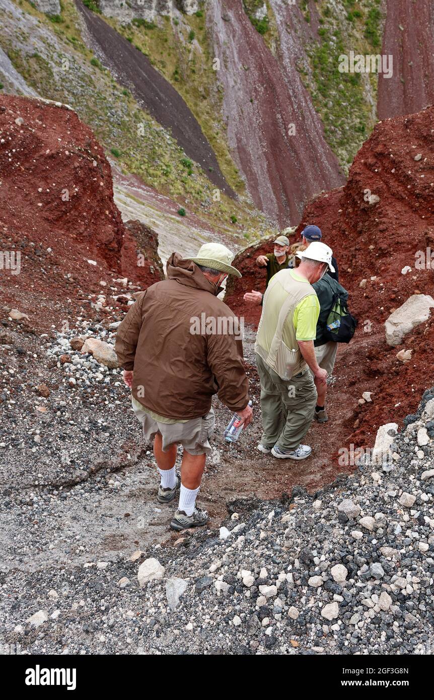 Männer wandern den Mt. Tarawera Krater, steiler Pfad, rutschiger Kies, braune Landschaft, stark, 2600 Meter tief, Sport, Abenteuer; Rotorua, Neuseeland, M Stockfoto