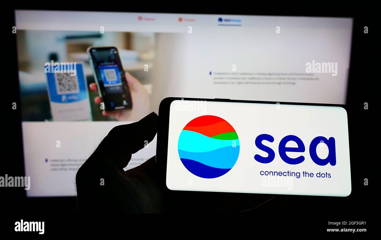 Person, die das Smartphone mit dem Logo des singapurischen Technologiekonzerns Sea Limited auf dem Bildschirm vor der Website hält. Konzentrieren Sie sich auf die Telefonanzeige. Stockfoto