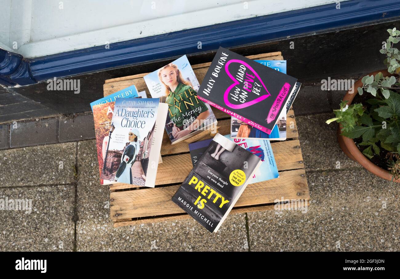 Auf einer Holzkiste vor einer Buchhandlung wurden verschiedene Bücher mit Papierrücklage gelegt. Stockfoto