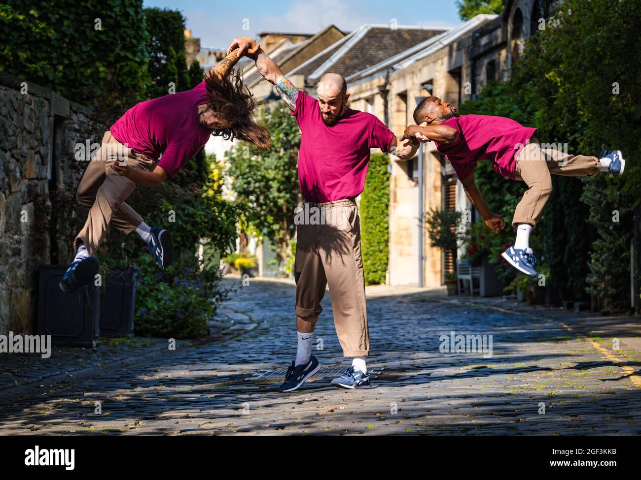 Akrobaten in kaum methodischer Truppe führen eine akrobatische Aufführung im Circus Lane, Edinburgh, Schottland, Großbritannien, durch Stockfoto