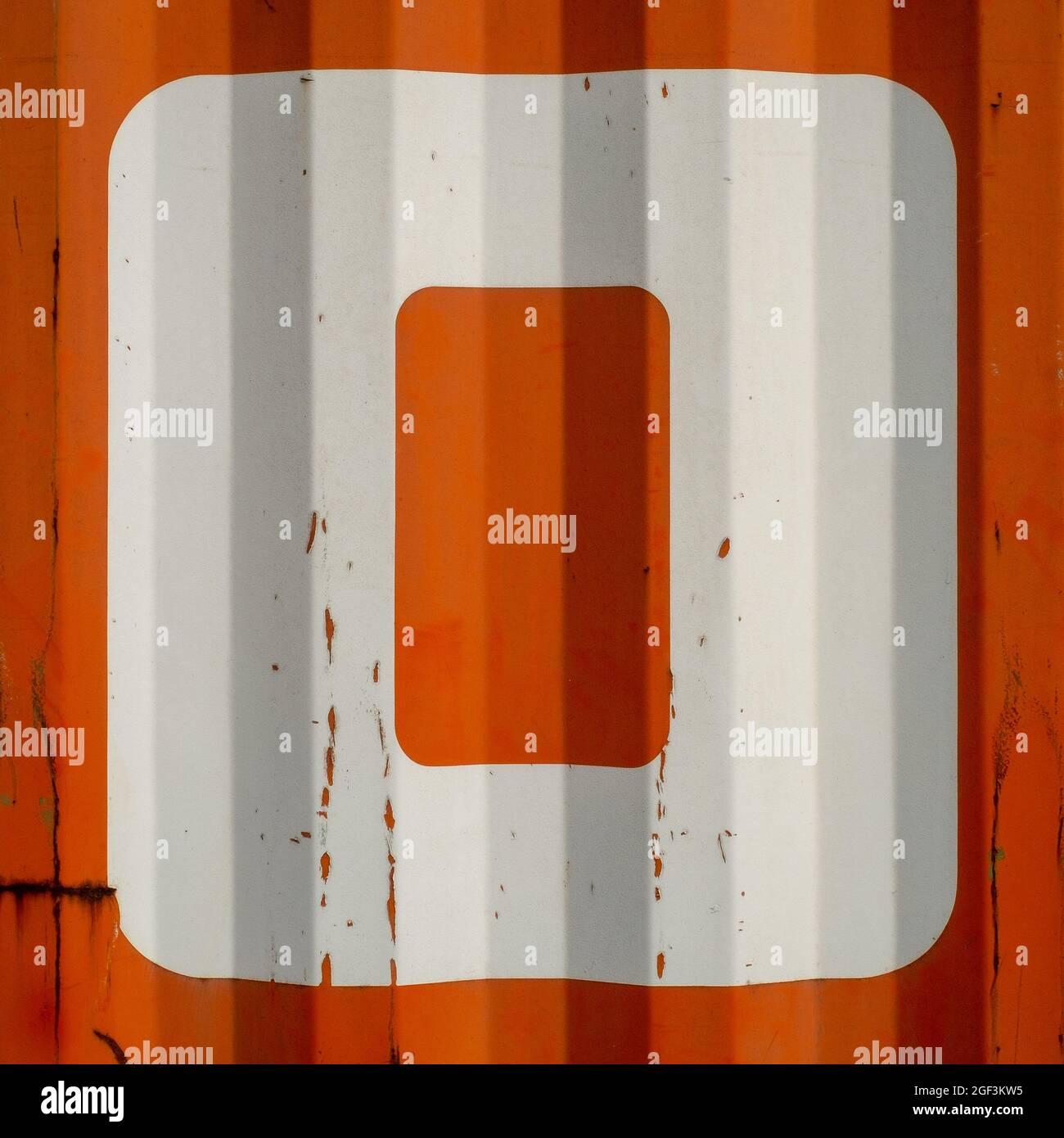 Grungen Sie einen Buchstaben O auf einem orangefarbenen gewellten emaillierten Metallhintergrund Stockfoto