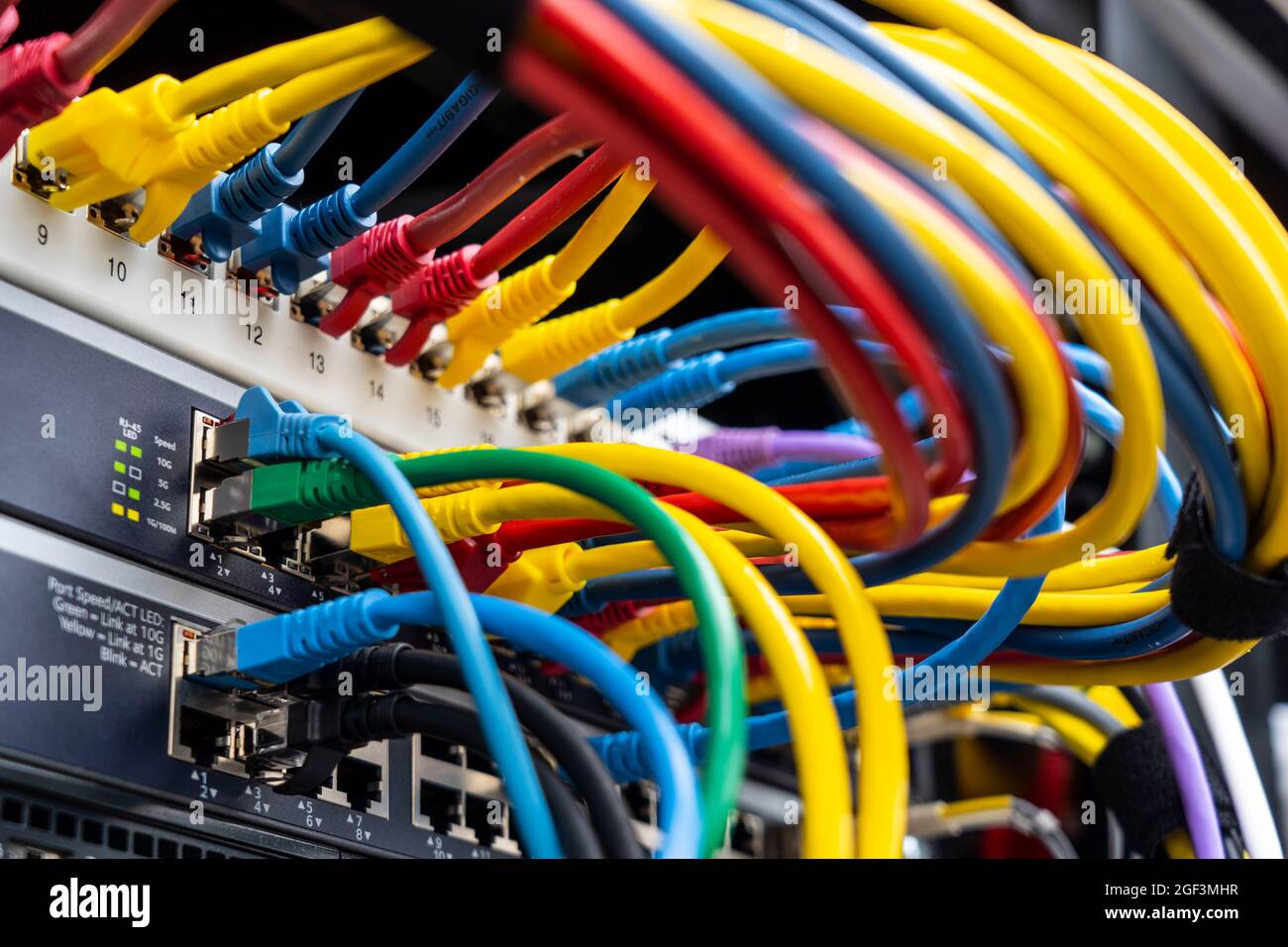 Kabel auf einem Computerserver eines Unternehmens, verschiedene Netzwerke konvergieren zentral auf dem Server, Stockfoto