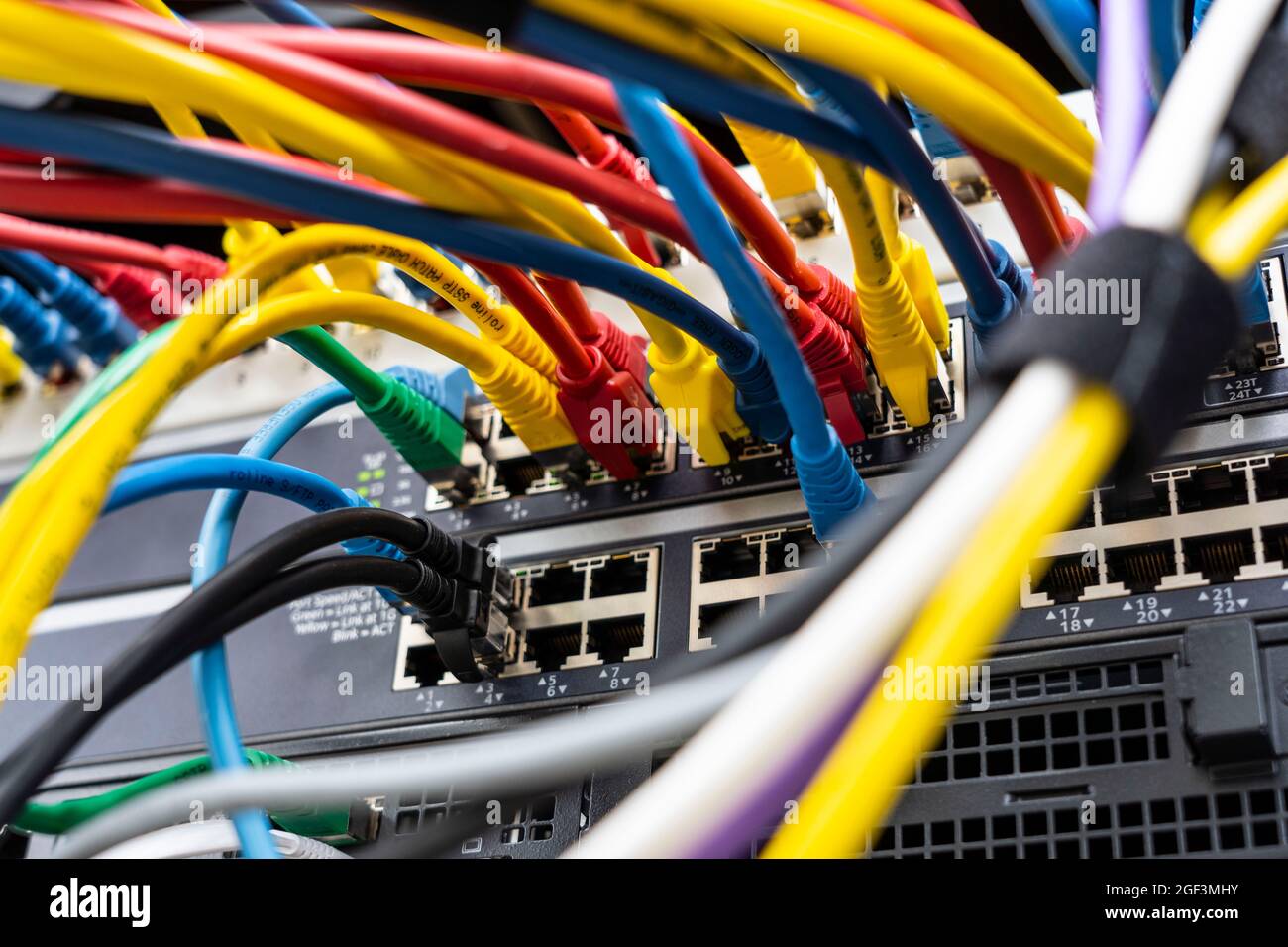 Kabel auf einem Computerserver eines Unternehmens, verschiedene Netzwerke konvergieren zentral auf dem Server, Stockfoto