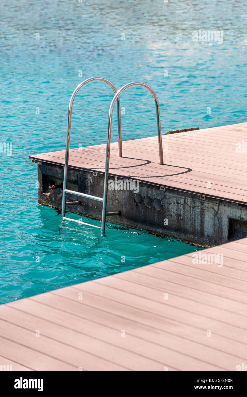 Schwimmende Anlegestelle mit Verbunddeck und Leiter an der Marina. Stockfoto