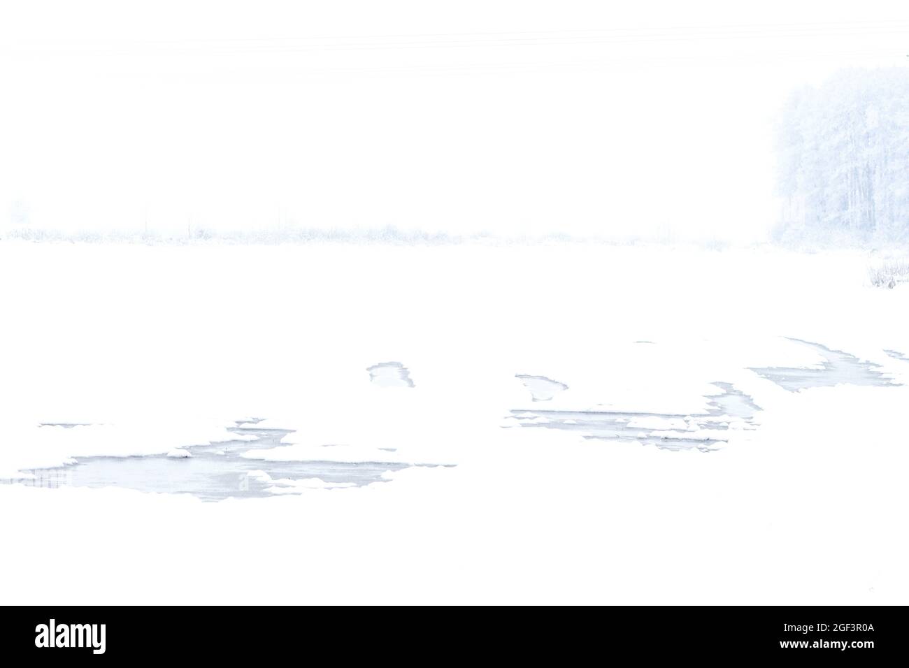 Pfützen auf dem schneebedeckten Feld im Winter bei Schneefall Stockfoto