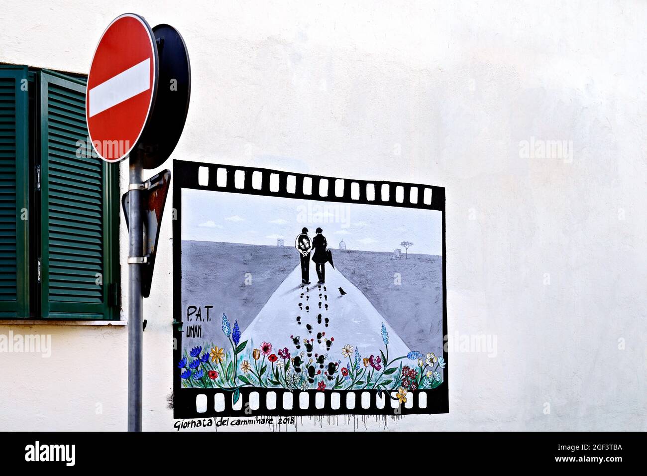 Blick auf ein Graffiti-Wandbild auf der Straße, das einen Filmrahmen darstellt, der an einer Wand eines Hauses im Stadtteil Trullo gemalt wurde. Rom, Italien, Europa. Speicherplatz kopieren Stockfoto