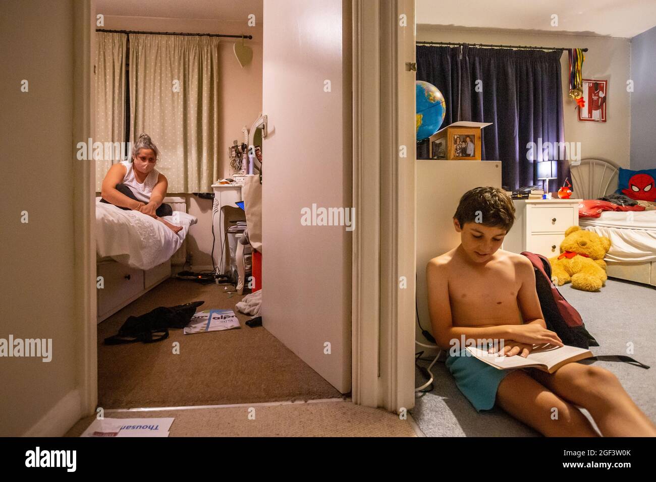 Mutter hört ihrem Sohn zu, liest Geschichte, während sie sich nach Covid-19 isoliert Stockfoto