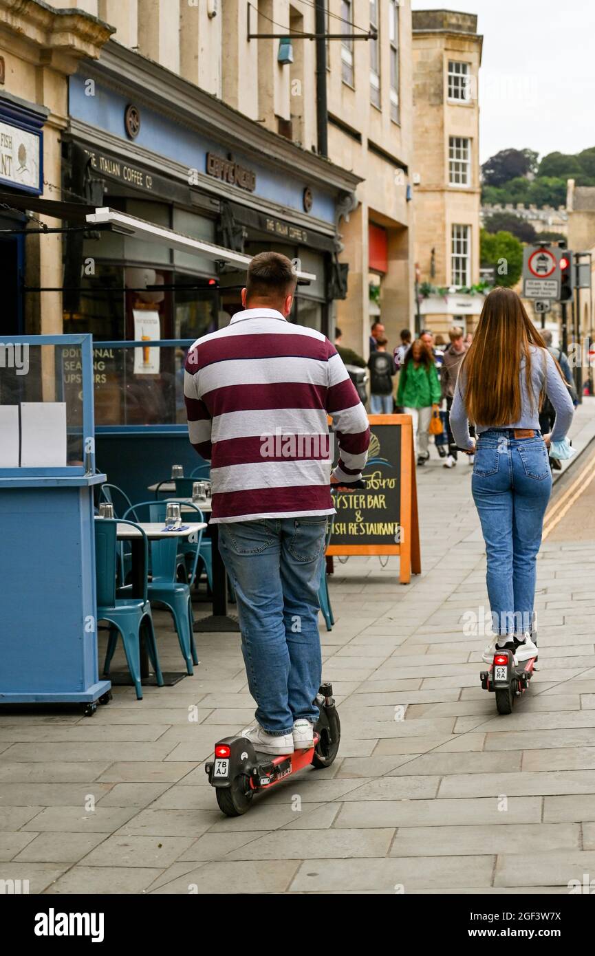 Bath, England - 2021. August: Zwei Personen fahren mit einem E-Scooter durch eine Fußgängerzone im Stadtzentrum Stockfoto