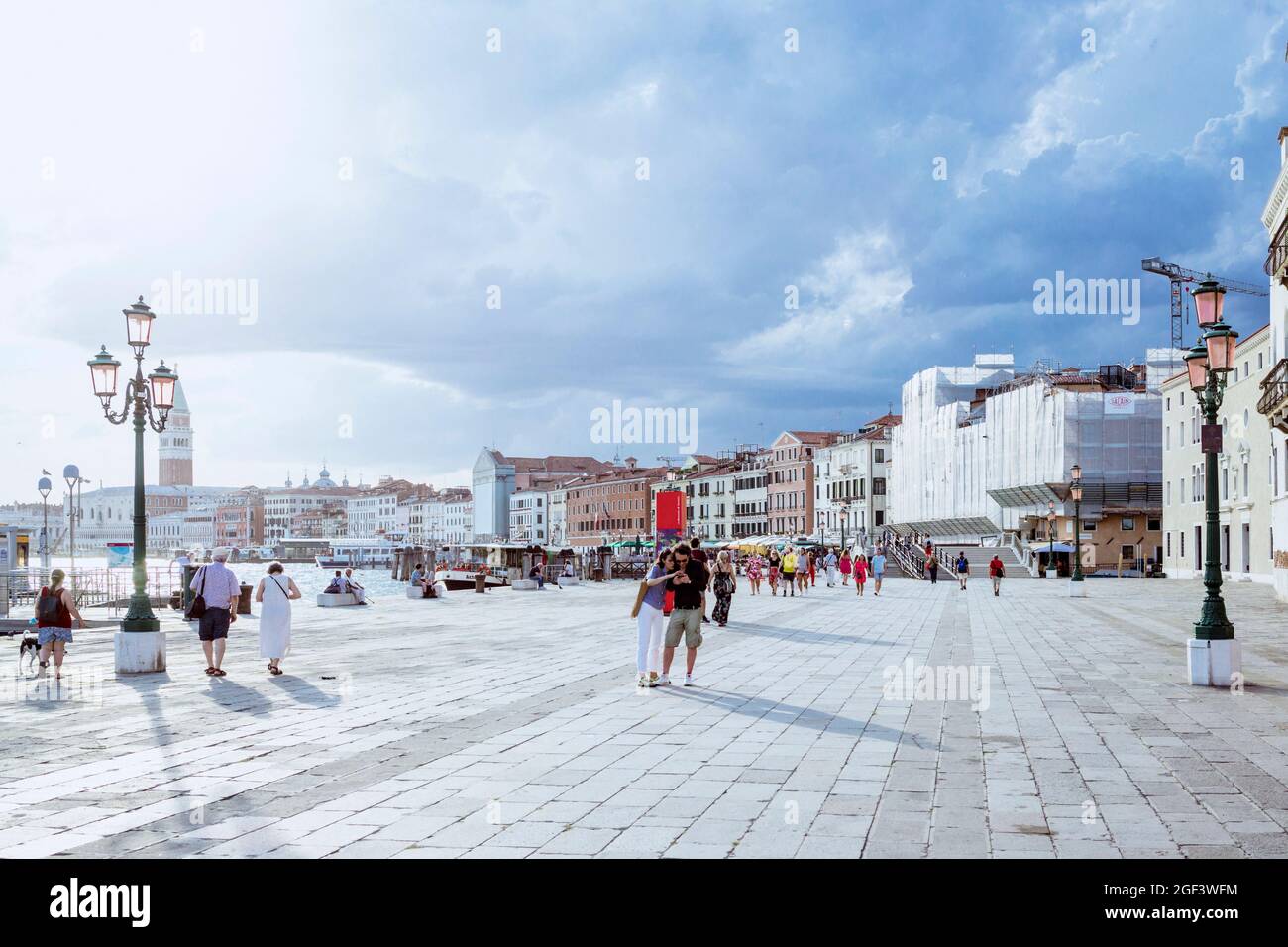 Touristen schlendern entlang der Riva degli Schiavoni Promenade in Venedig, Italien. August 2021 Stockfoto