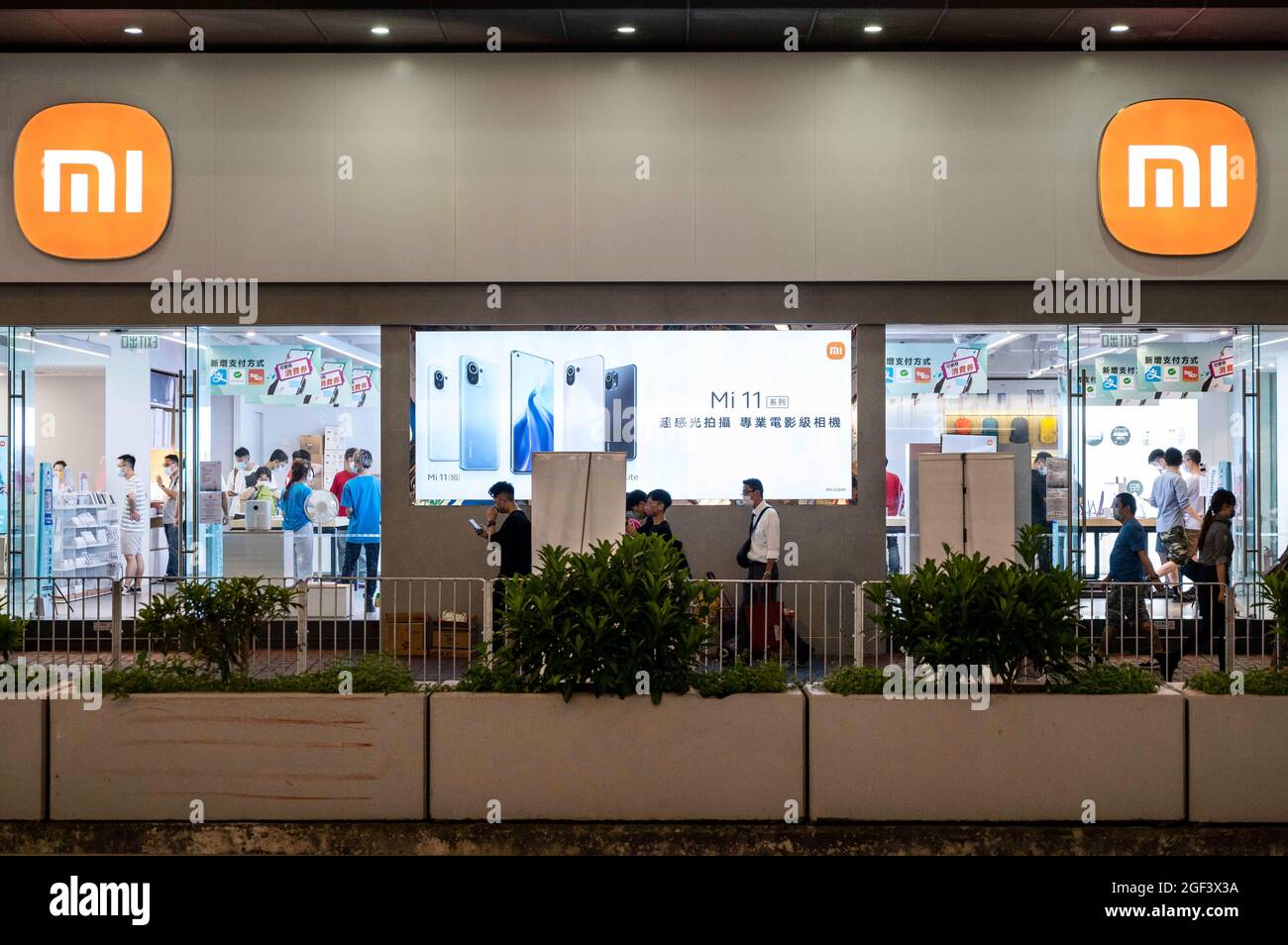 Hongkong, China. August 2021. Fußgänger kommen an der chinesischen multinationalen Technologie- und Elektronikmarke Xiaomi mit ihrem neuen abgerundeten Kantenlogo in Hongkong vorbei. (Bild: © Budrul Chukrut/SOPA Images via ZUMA Press Wire) Stockfoto
