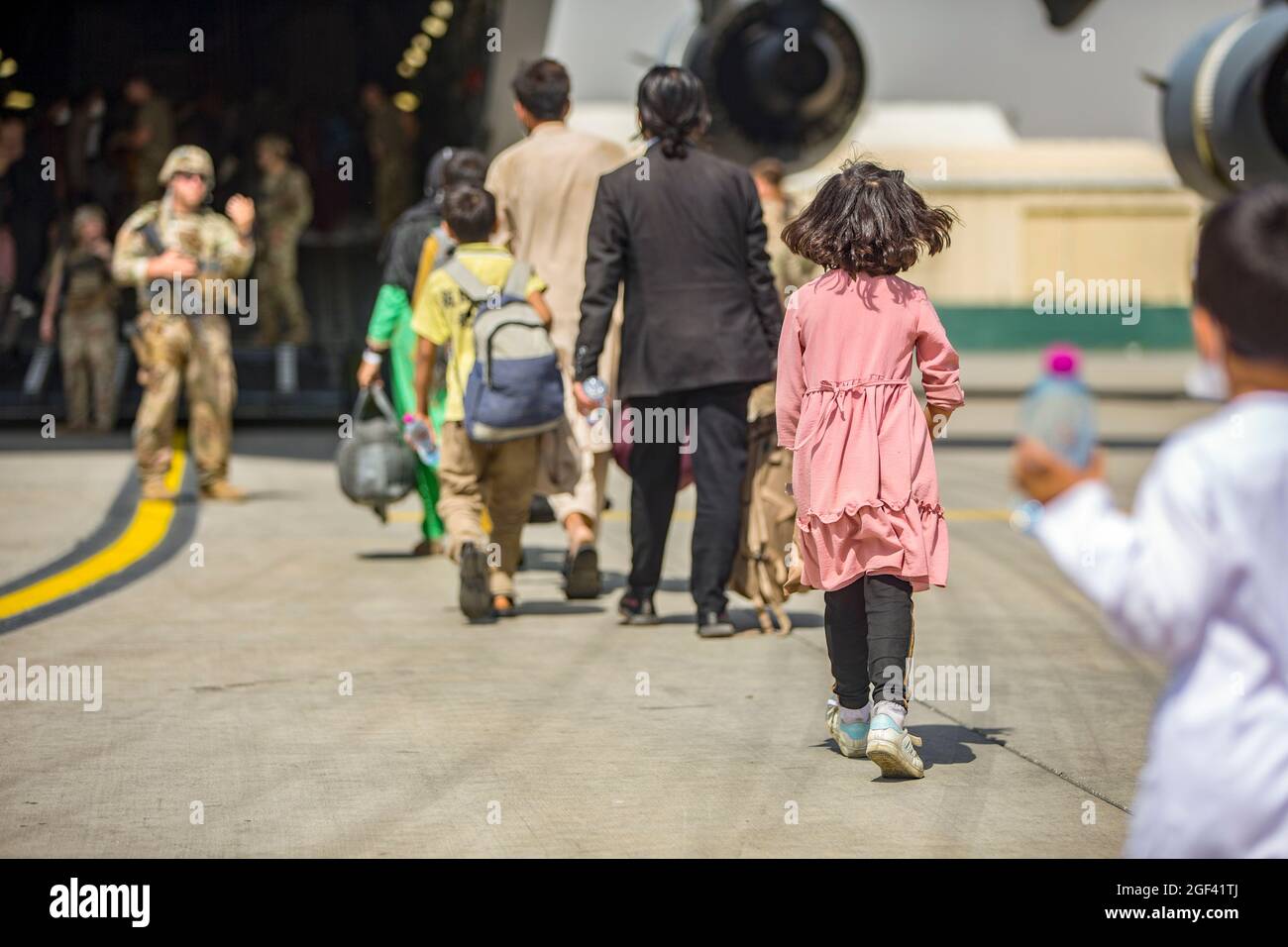 Familien beginnen, während einer Evakuierung am Hamid Karzai International Airport, Kabul, Afghanistan, am 23. August an Bord einer Boeing C-17 Globemaster III der US-Luftwaffe zu gehen. US-Dienstmitglieder unterstützen das Außenministerium bei einer geordneten Abseichung von designiertem Personal in Afghanistan. (USA Marine Corps Foto von Sgt. Samuel Ruiz über American Photoarchive/Alamy) Stockfoto