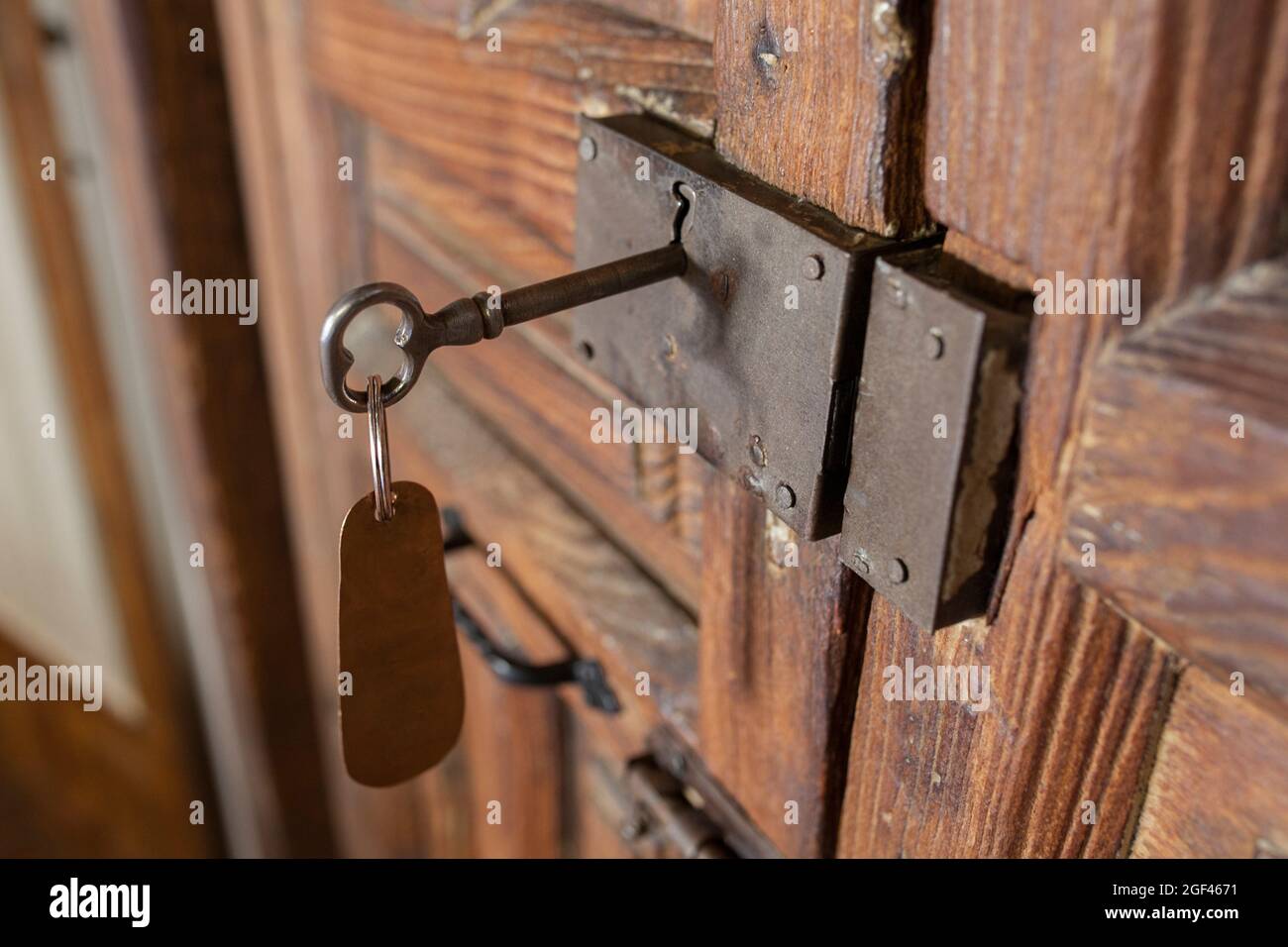 Schlüsselschloss im ländlichen Zimmer mit Anhänger. Konzept des ländlichen Tourismus. Stockfoto