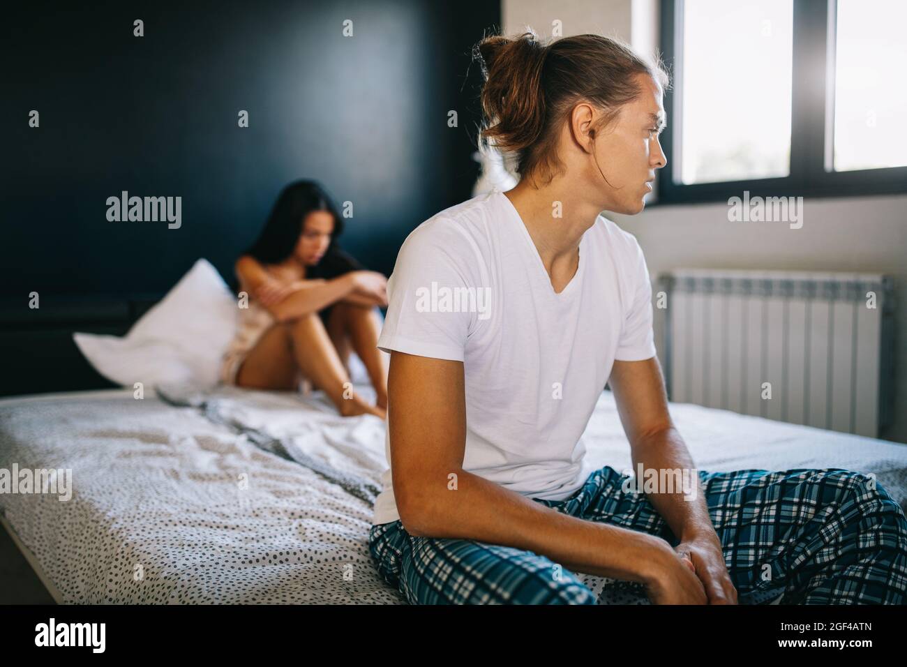 Junges Paar im Bett mit Problemen und Krise. Scheidung und Trennung Stockfoto