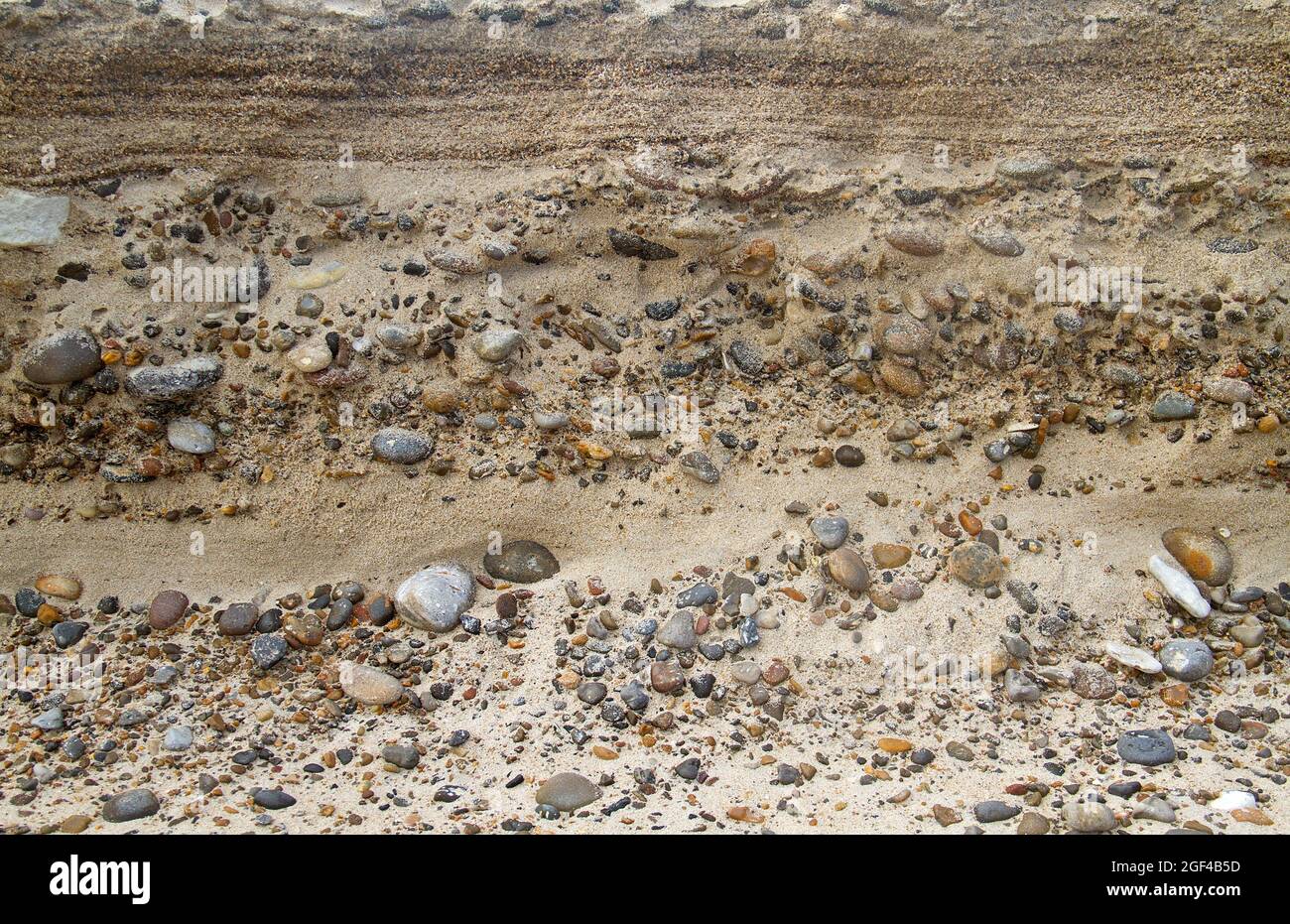 Wechsel von Sand- und Kiesschichten in einem Sediment in der Nähe der Küste Stockfoto