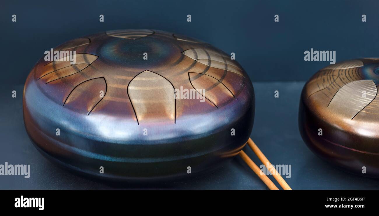 Stahlzunge, Trommel. Klangschale, Stahltrommel und Drumsticks. Instrument für Klangwellentherapie und Meditation, Heilung. Stockfoto
