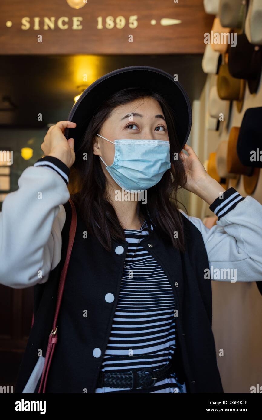 Schöne junge asiatische Frau, die in San Francisco Hüte kauft Stockfoto