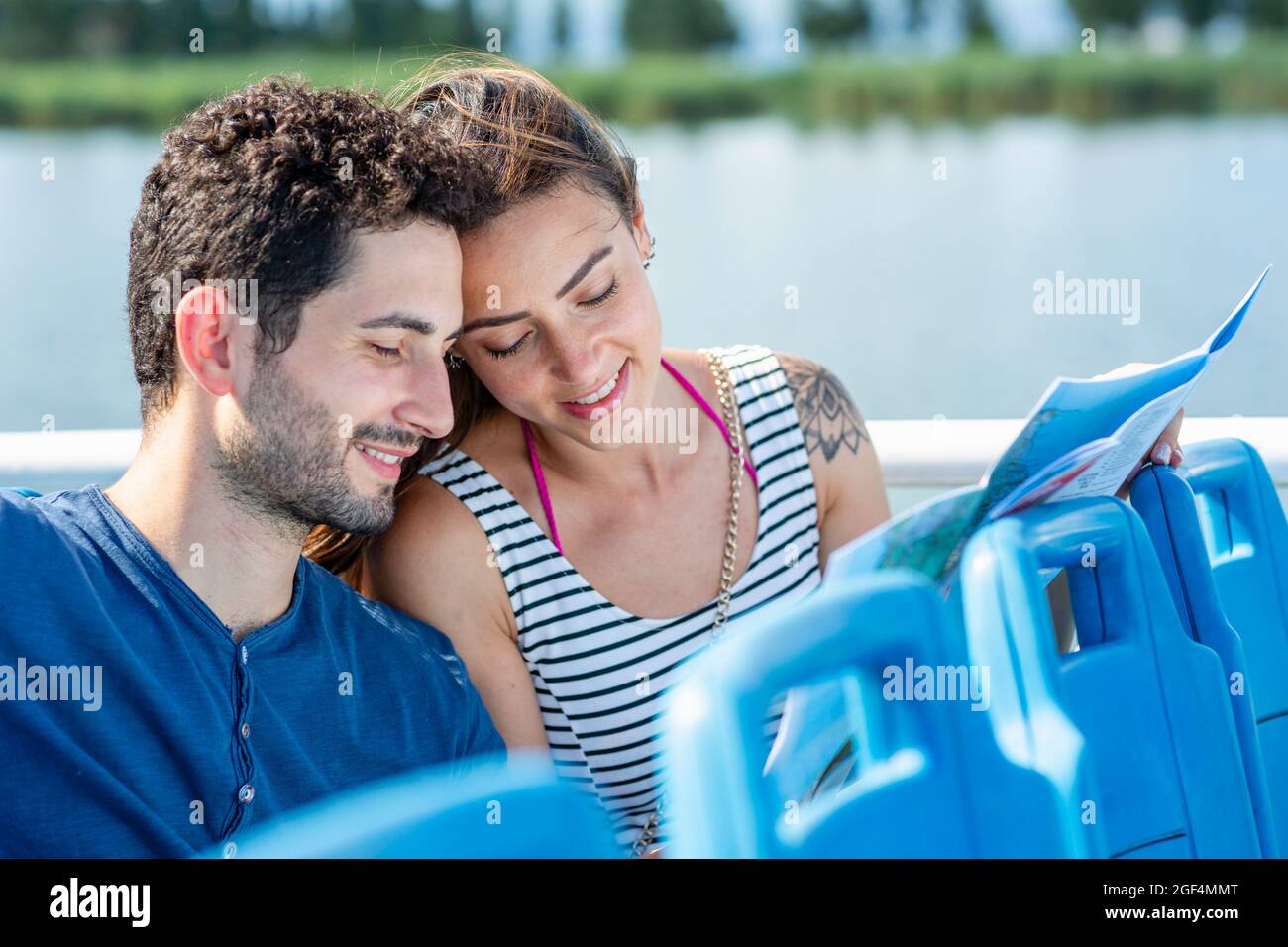 Touristen-Paar, die die Karte überprüfen, während sie im Passagierschiff sitzen Stockfoto