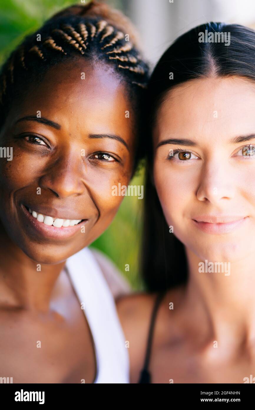 Multiethnische Freundinnen lächeln zusammen Stockfoto