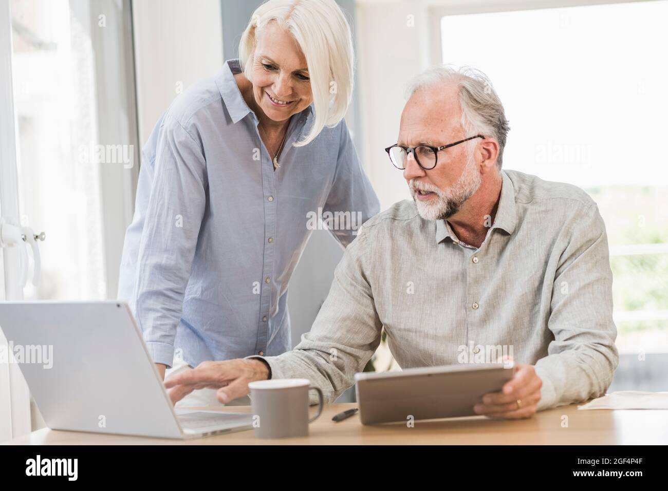 Professionelle und weibliche Mitarbeiter, die drahtlose Technologien nutzen, während sie im Home Office arbeiten Stockfoto