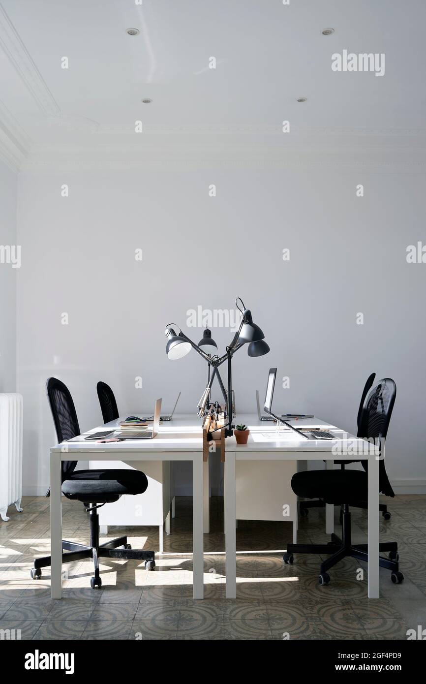 Elektrische Lampen auf den Schreibtischen im Büro Stockfoto