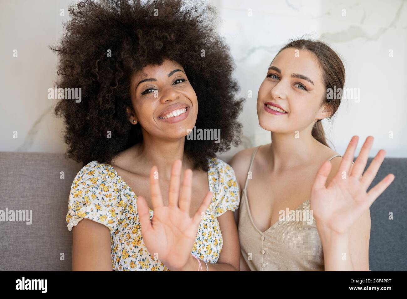 Multiethnische Freundinnen winken zu Hause Stockfoto