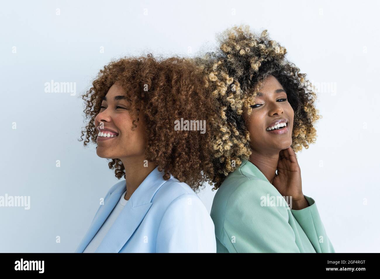 Lächelnde weibliche Profis stehen vor weißem Hintergrund Stockfoto