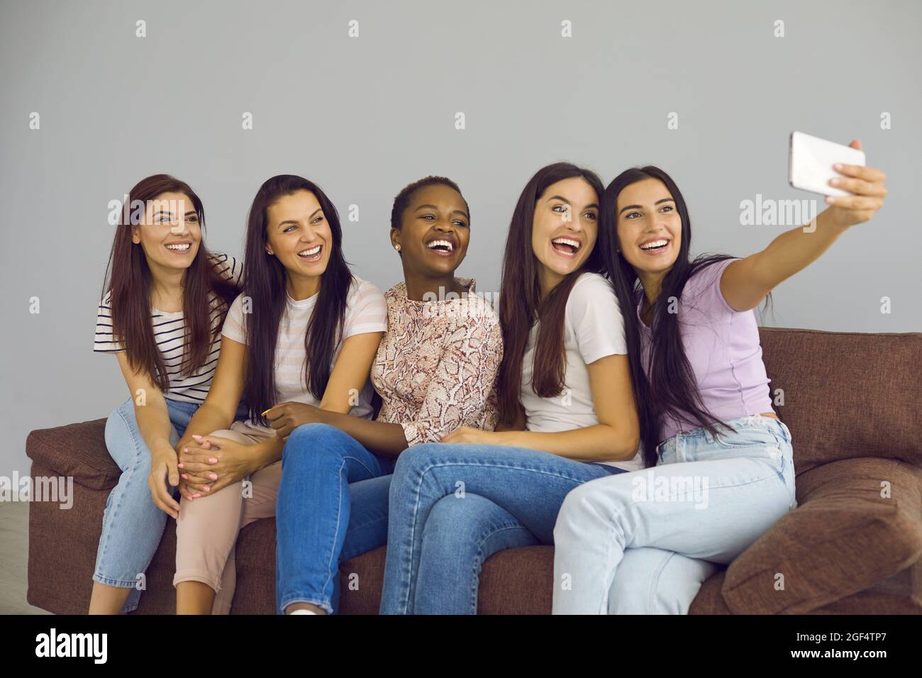 Eine vielfältige Gruppe von glücklichen jungen Frauen, die zu Hause Selfie auf dem Handy auf einer lustigen Party machen Stockfoto