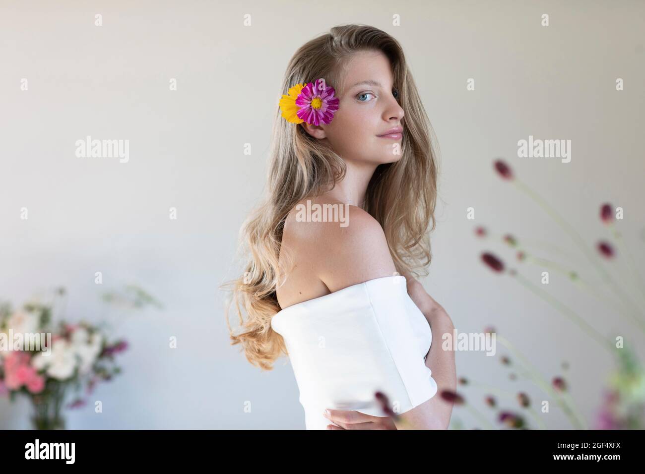 Schöne Frau mit Blumen in blonden Haaren Stockfoto