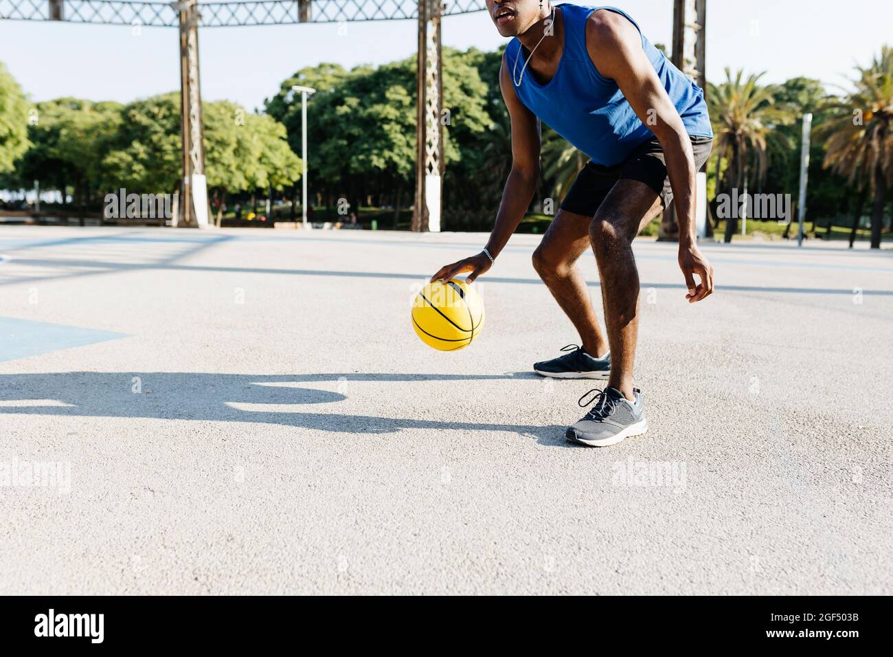 Männlicher Basketballspieler, der auf dem Sportplatz spielt Stockfoto