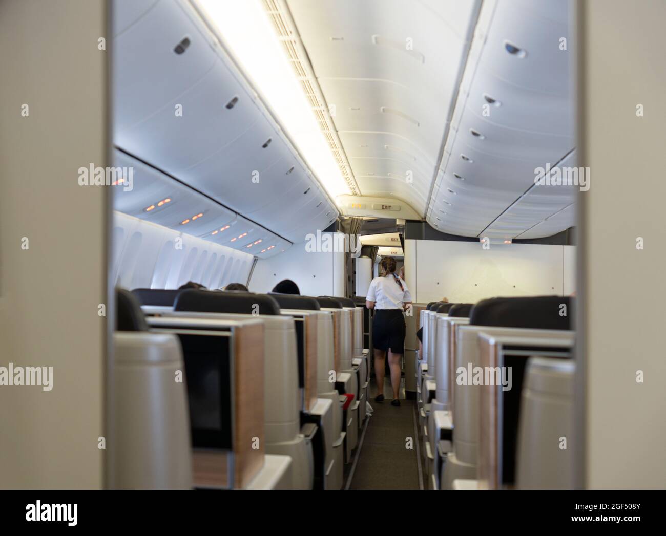 Schweiz - Juli 19 2021: Flugbegleiter und Passagiere an Bord des Swissair-Fluges von NY nach Zürich. Business Class und Gang von hinten Stockfoto