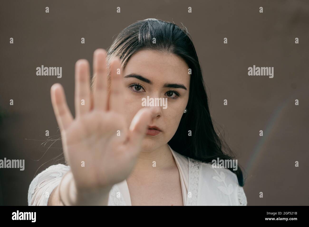 Junge Frau gestikuliert Stoppschild mit der Hand Stockfoto