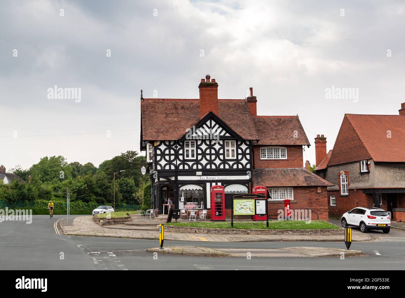 Port Sunlight, Wirral, Großbritannien: TUDOR Rose Tea Rooms, Kreuzung von Greendale Road und Park Road, mit roten Telefonzellen im K2-Design. Stockfoto