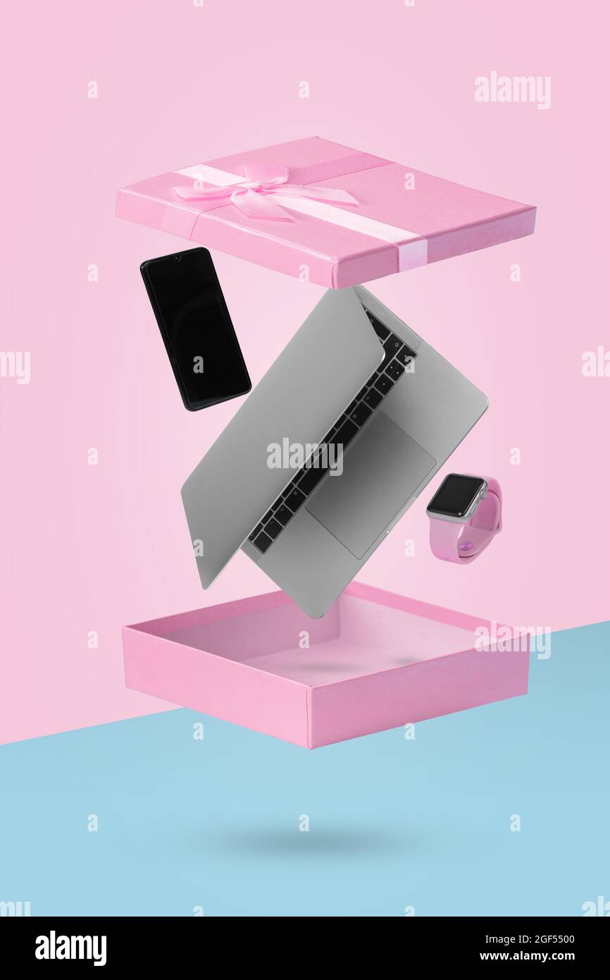 Laptop-Computer, Smartphone und Smartwatch in offener Geschenkbox, während Sie in der Luft schweben. Kreatives Minimalkonzept von Geschenken und Lieferung. Geeignet Stockfoto