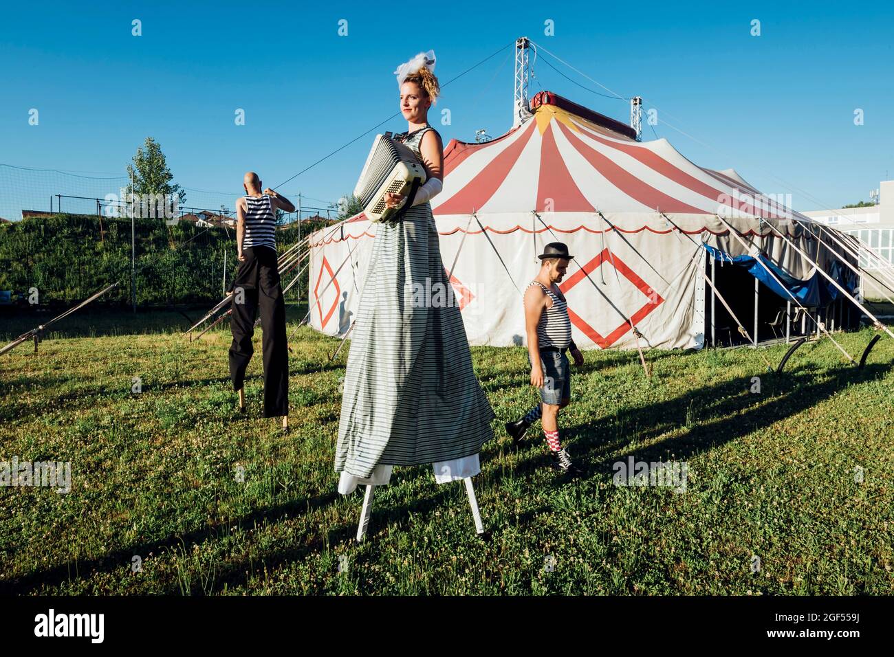 Zirkuskünstler treten beim Spaziergang auf der Wiese auf Stockfoto