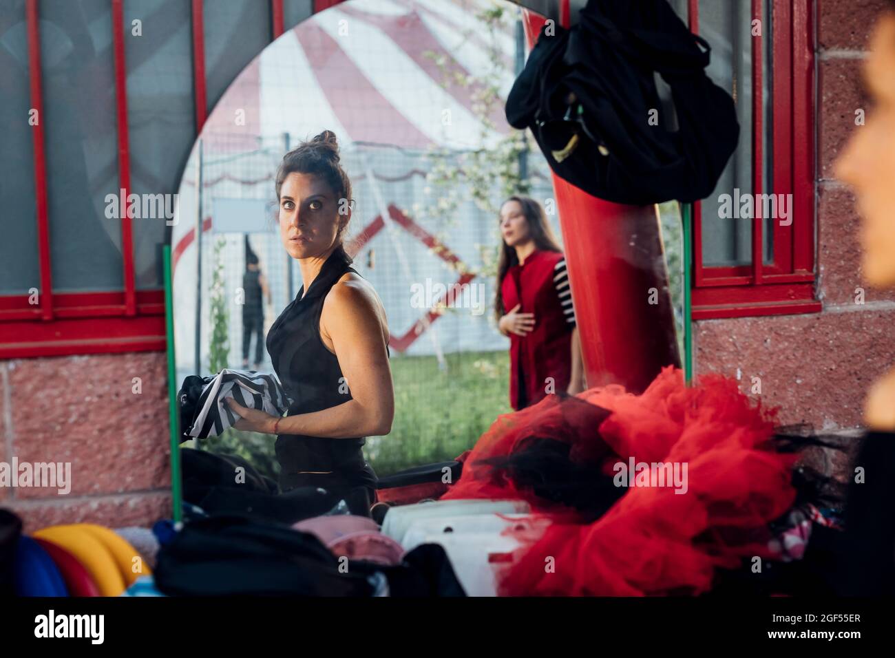 Spiegelung weiblicher Künstler im Zirkuszelt Stockfoto