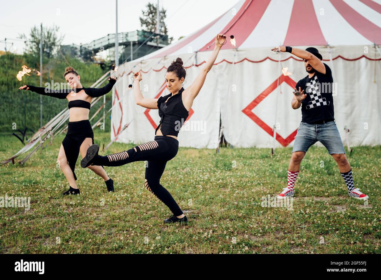 Männliche und weibliche Performerinnen üben vor dem Zirkuszelt Stockfoto