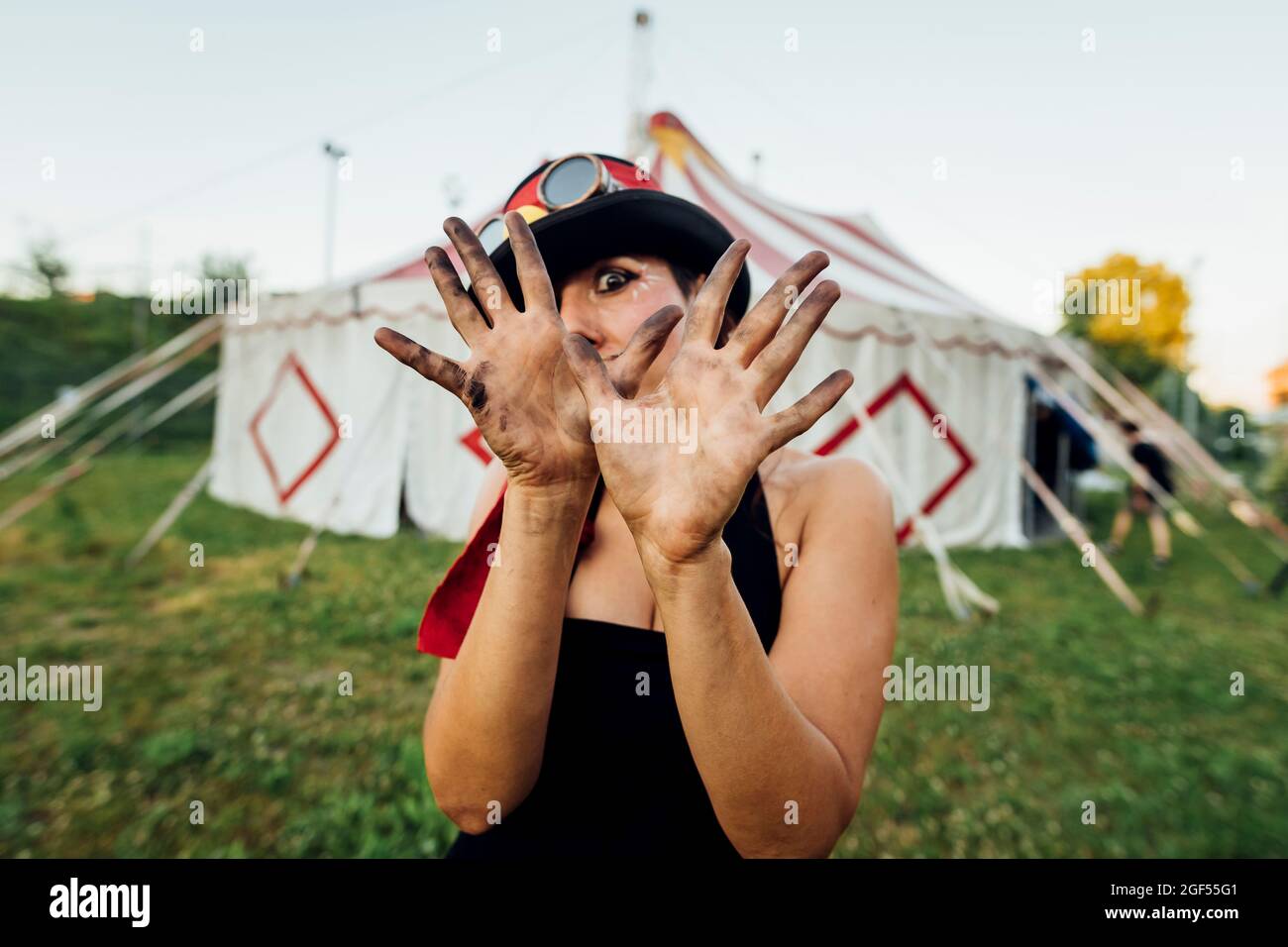Eine Künstlerin, die eine Stoppgeste zeigt, während sie vor dem Zirkuszelt steht Stockfoto