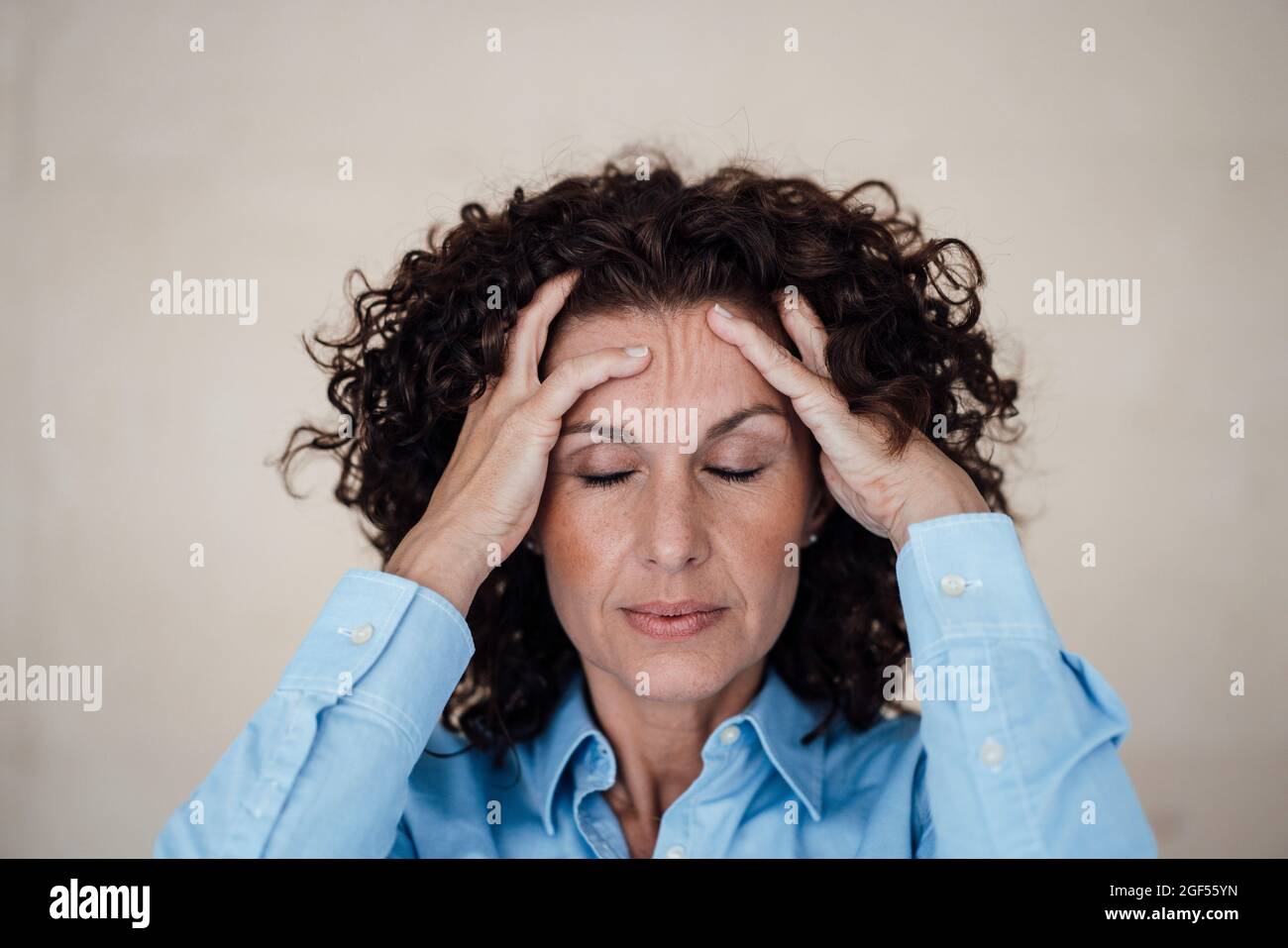 Überarbeitete Geschäftsfrau mit geschlossenen Augen im Büro Stockfoto