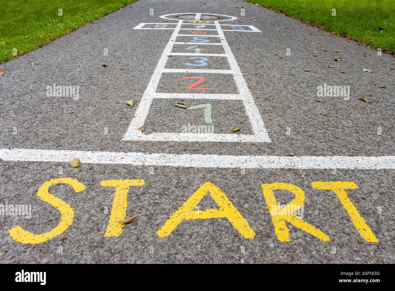 Eine gezeichnete Figur für ein Kinderspiel - hopscotch auf einer asphaltierten Straße Stockfoto