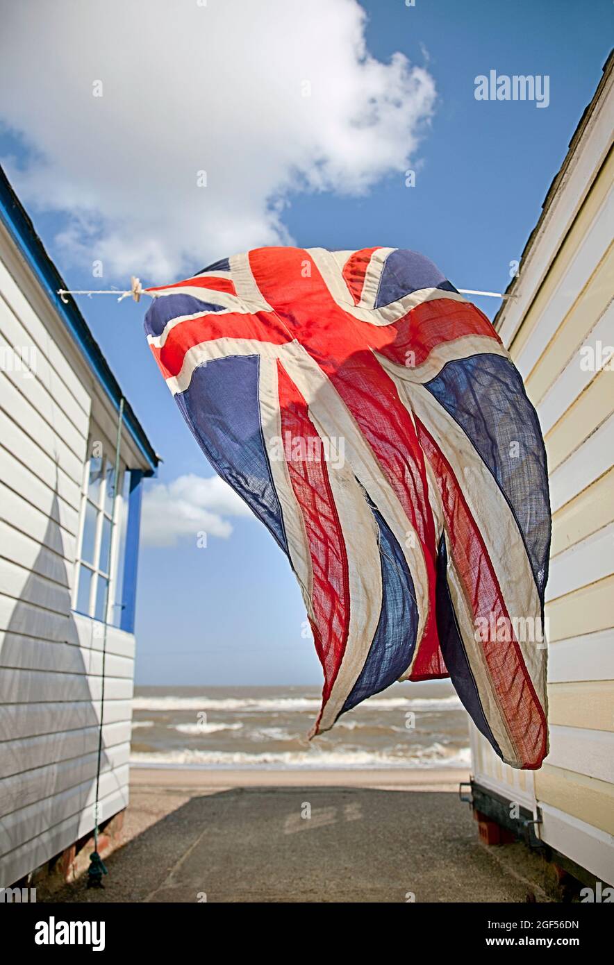 Britische Flagge hängt an sonnigen Tagen zwischen Strandhütten Stockfoto