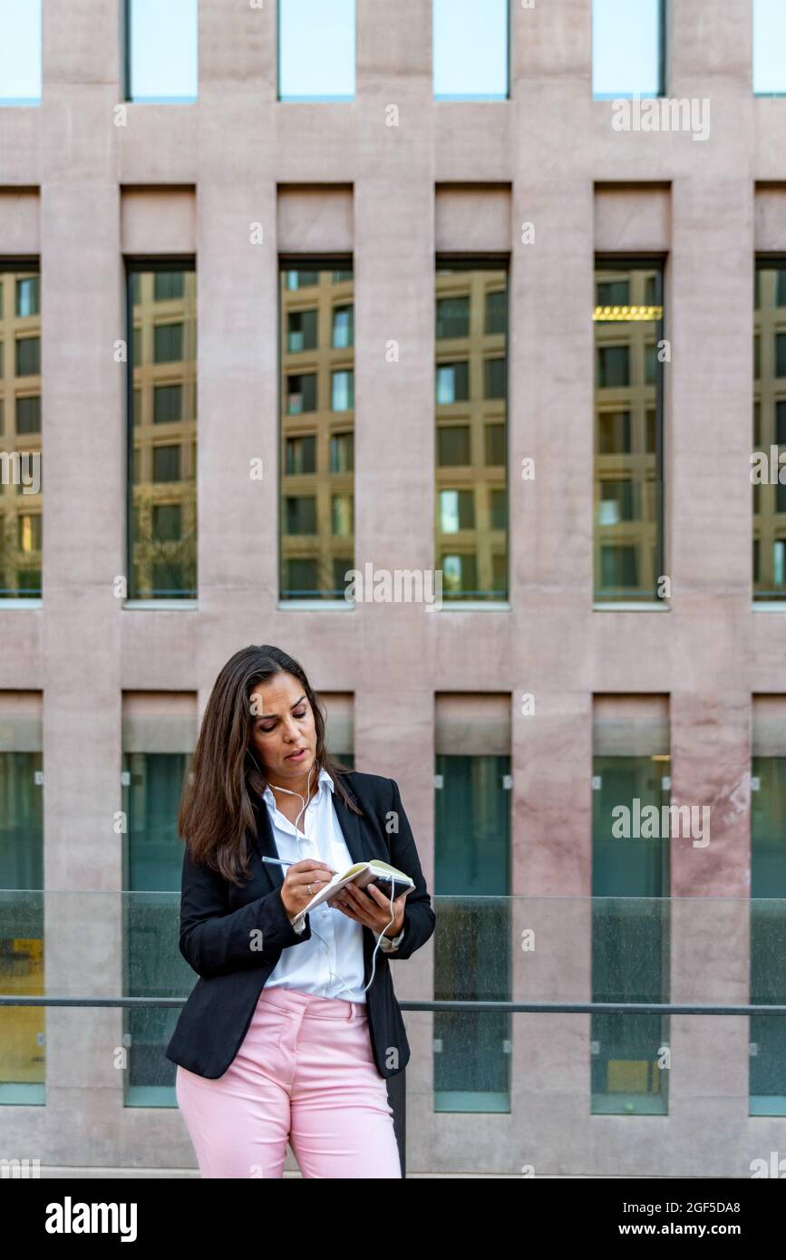 Kaukasische Geschäftsfrau mit Notebook in der Stadt Stockfoto
