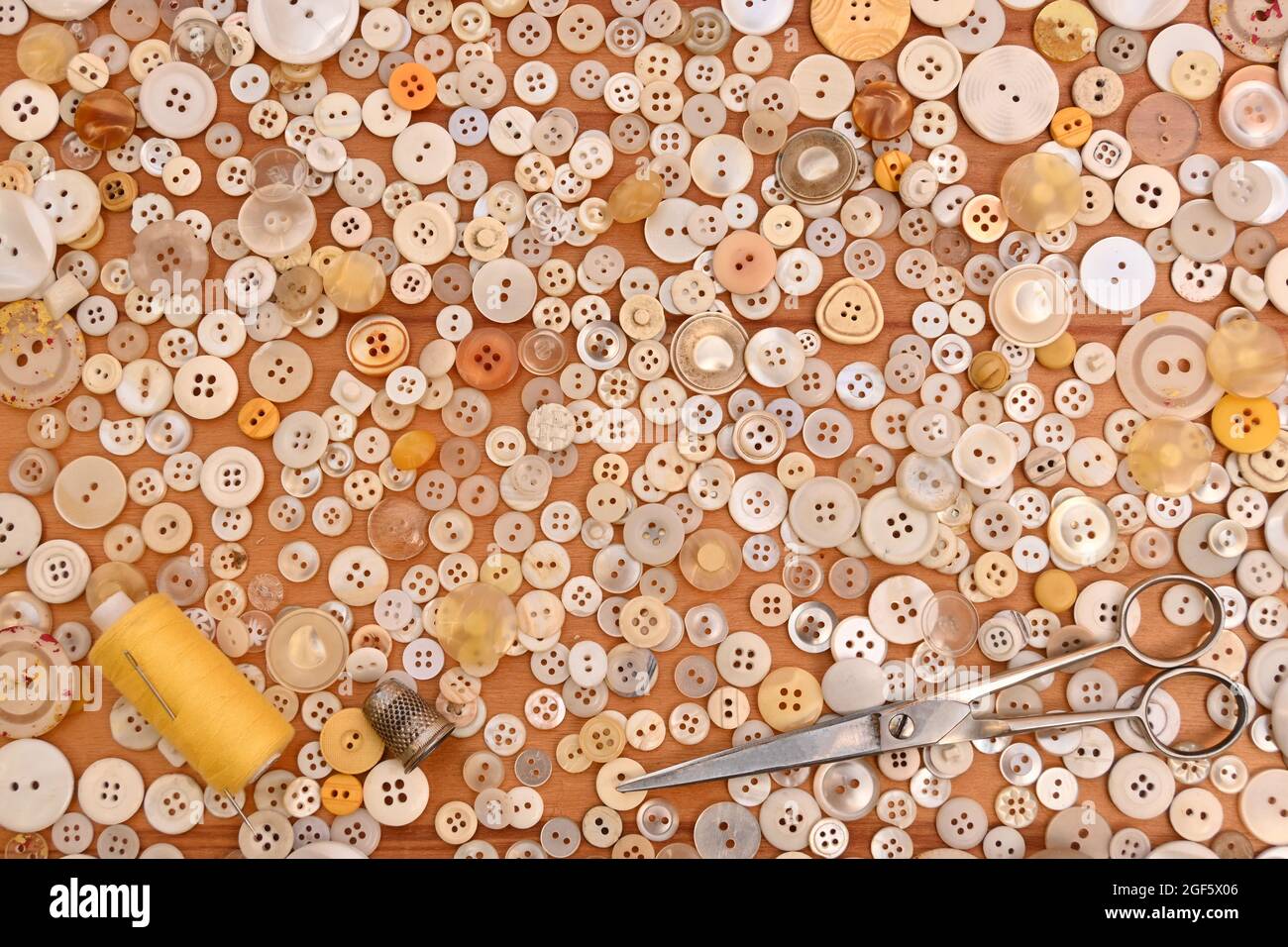 Näherin, Knöpfe, Schere, Handflink, Faden und Nadel zum Nähen. Gelb Stockfoto