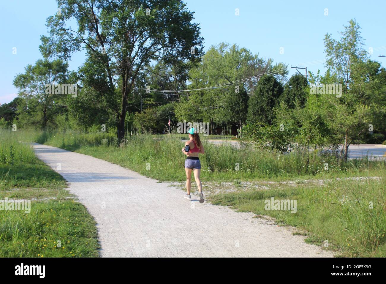 Junge Frau, die auf dem des Plaines River Trail in den Iroquois Woods in Park Ridge, Illinois, läuft Stockfoto